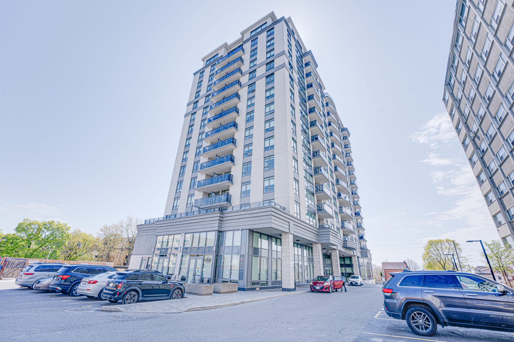 Royal Heights, a fifteen storey tower of pale stone with a column of blue glass balconies, seen from the street